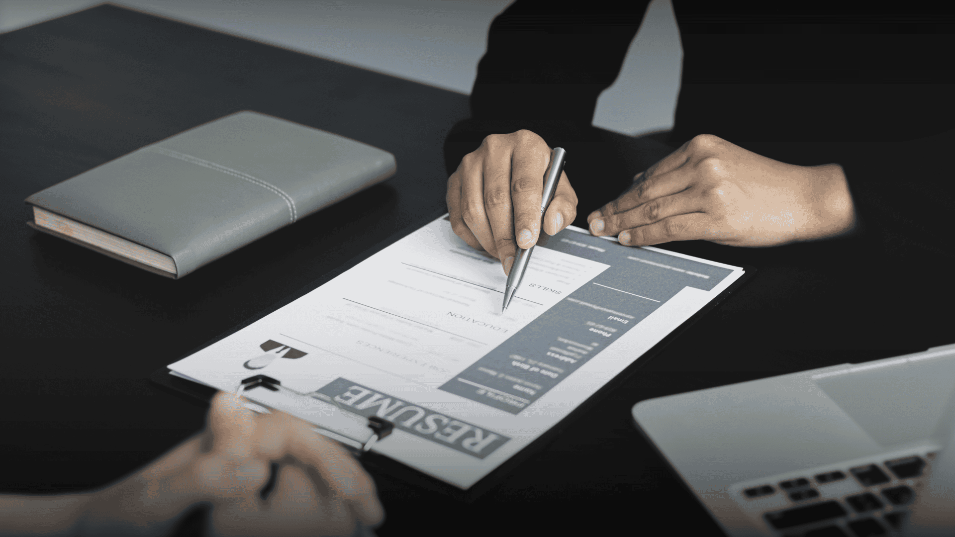 Close-up of a recruiter using a pen to scan a resume, highlighting how recruiters actually read resumes during the hiring process.