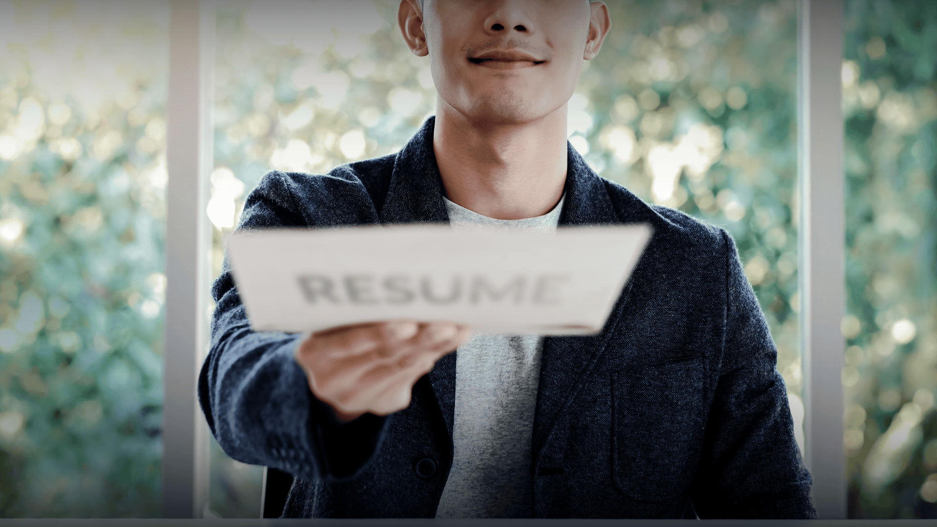 A confident job candidate handing over a resume, demonstrating the story-based resume approach to stand out to employers.