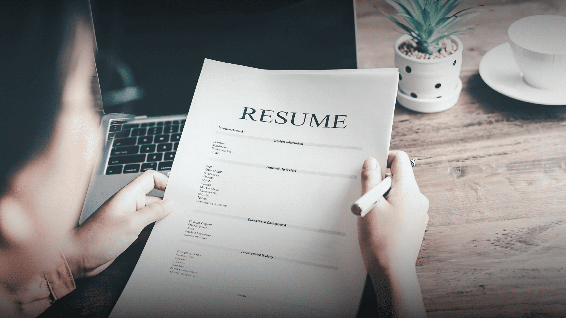 Overhead view of a person holding a final resume draft, representing a strong first impression in the job market.