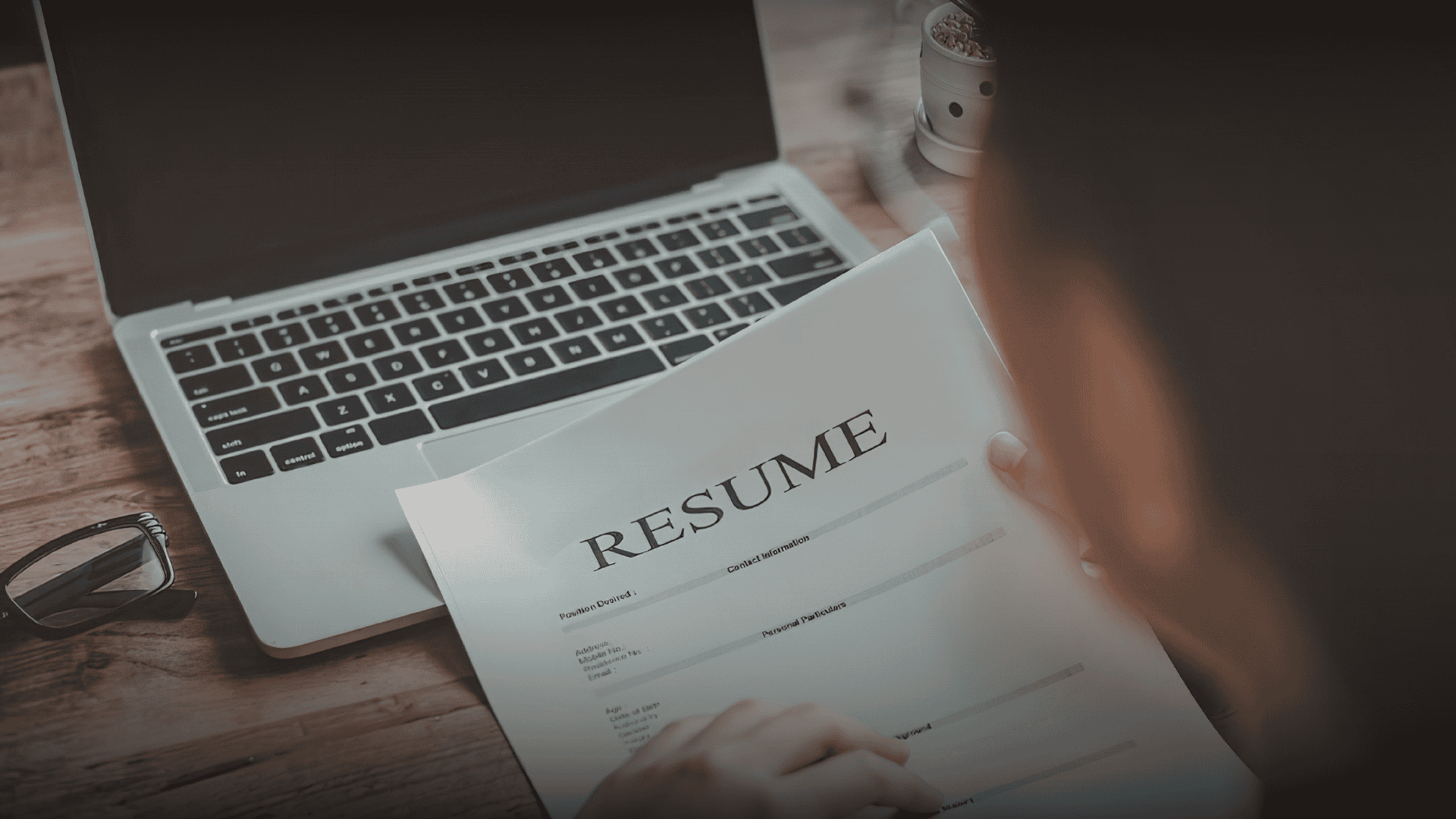 A professional looking at a resume layout on a desk, illustrating resume writing tips to get more interviews fast.